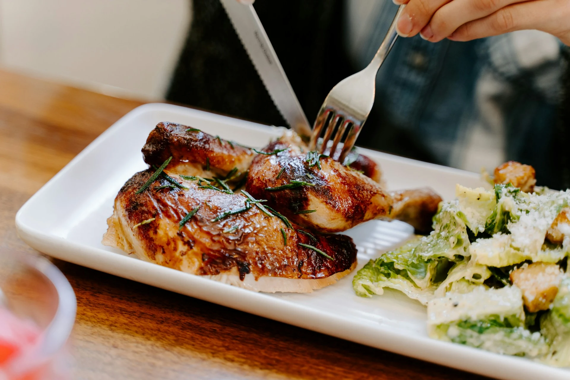 Grilled chicken with a green salad on a white plate