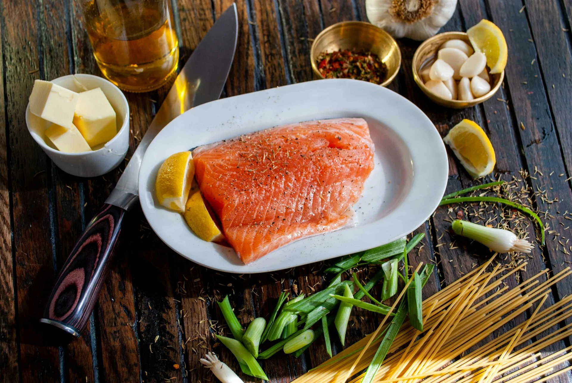 Raw salmon, lemon, herbs and other ingredients laid out for preparation