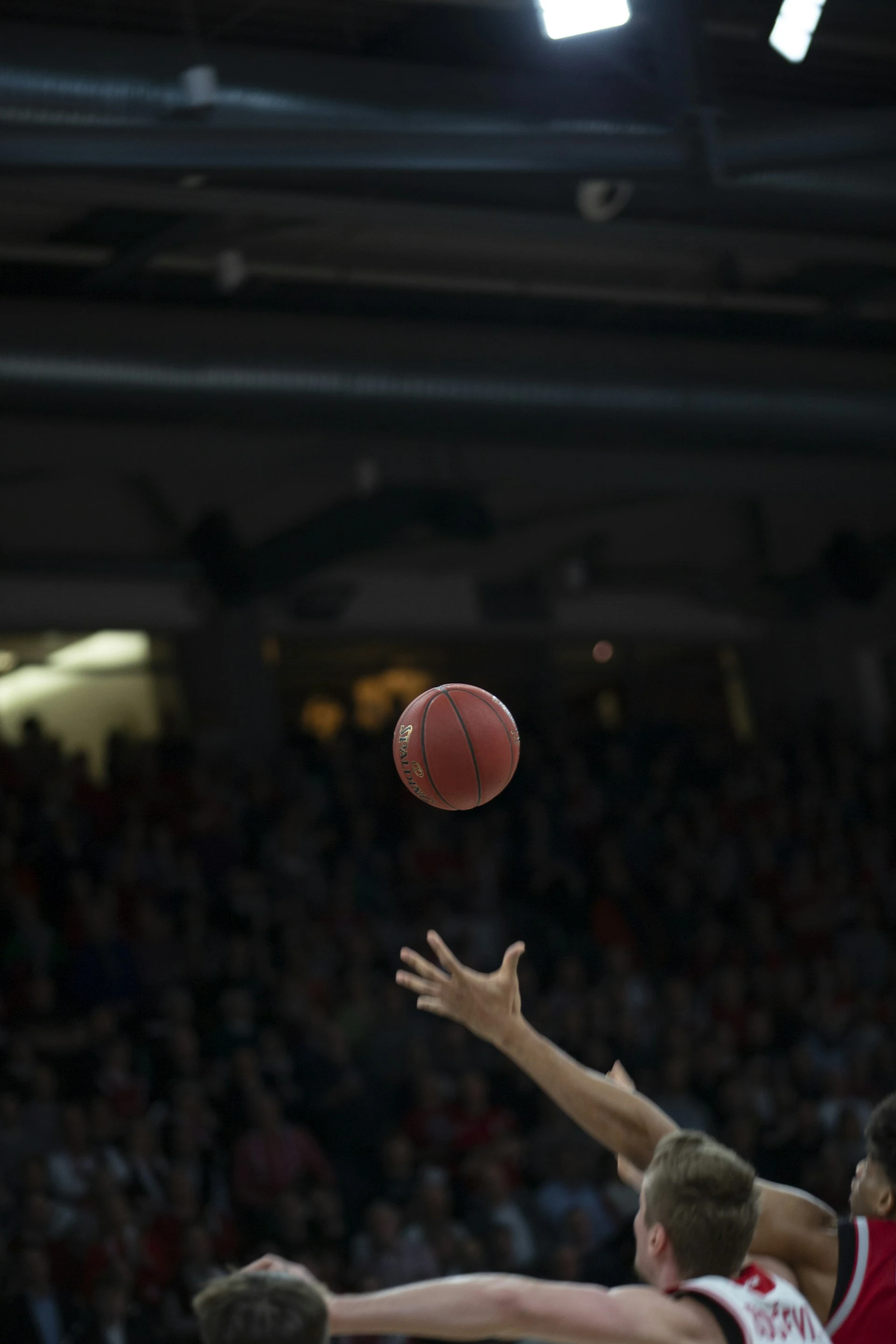 A basketball player extending toward the ball during play